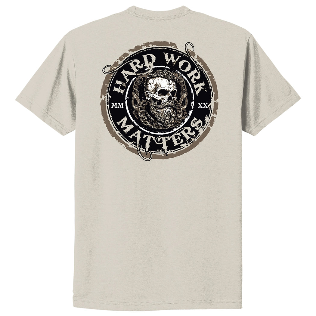 Back of a WW Sand color Graphic Tee, imprinted with "HARD WORK MATTERS" circular text and a rugged skull image in Viking-style design in center of circular image, on full back width in Black, Brown and White inks. (MMXX Roman numerals on the left/right of design printed small.)