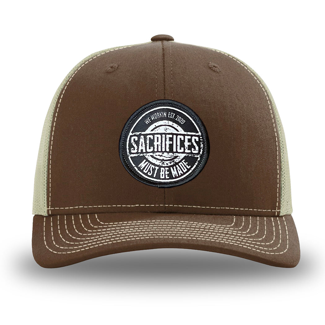 Brown/Khaki WeWorkin hat—Richardson 112 brand snapback, retro trucker classic hat style. WeWorkin "SACRIFICES Must Be Made" circular woven patch, with black/white thread colors and black merrowed edge, is centered on the front panels.