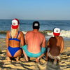 A woman, man and child wearing WeWorkin Foam Trucker Snapback Hats in 3 different colorways, pictured outdoors from back, wearing hats backwards. They are wearing the PASSION IS PRICELESS, BLUE COLLAR DOLLAR-VINTAGE AND TRUMP design options.