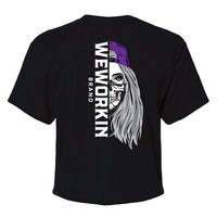 Back of a We Workin Women's short-sleeve cropped tee in Black—with a large imprint of our "WEWORKIN BRAND vertical text and Half Skull Woman with Hat" design in Black/White/Grey (hat graphic highlighted in Purple ink.)