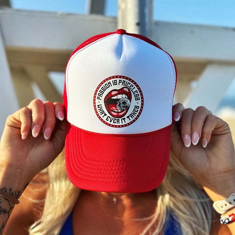 Woman wearing a WeWorkin Foam Trucker Snapback Hat in a Red/White colorway, pictured outdoors, from the front. The design features a circular red-beaded border on white background with red lips-mouth "crunching down" on a skull between teeth in the center, the text "PASSION IS PRICELESS • WHAT EVER IT TAKES" encircling center graphic in black ink.