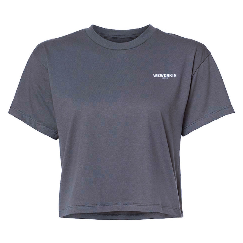 Front of a We Workin Women's short-sleeve cropped tee in Dark Grey—with a small imprint of our "WEWORKIN BRAND" icon on the upper left chest in White ink.