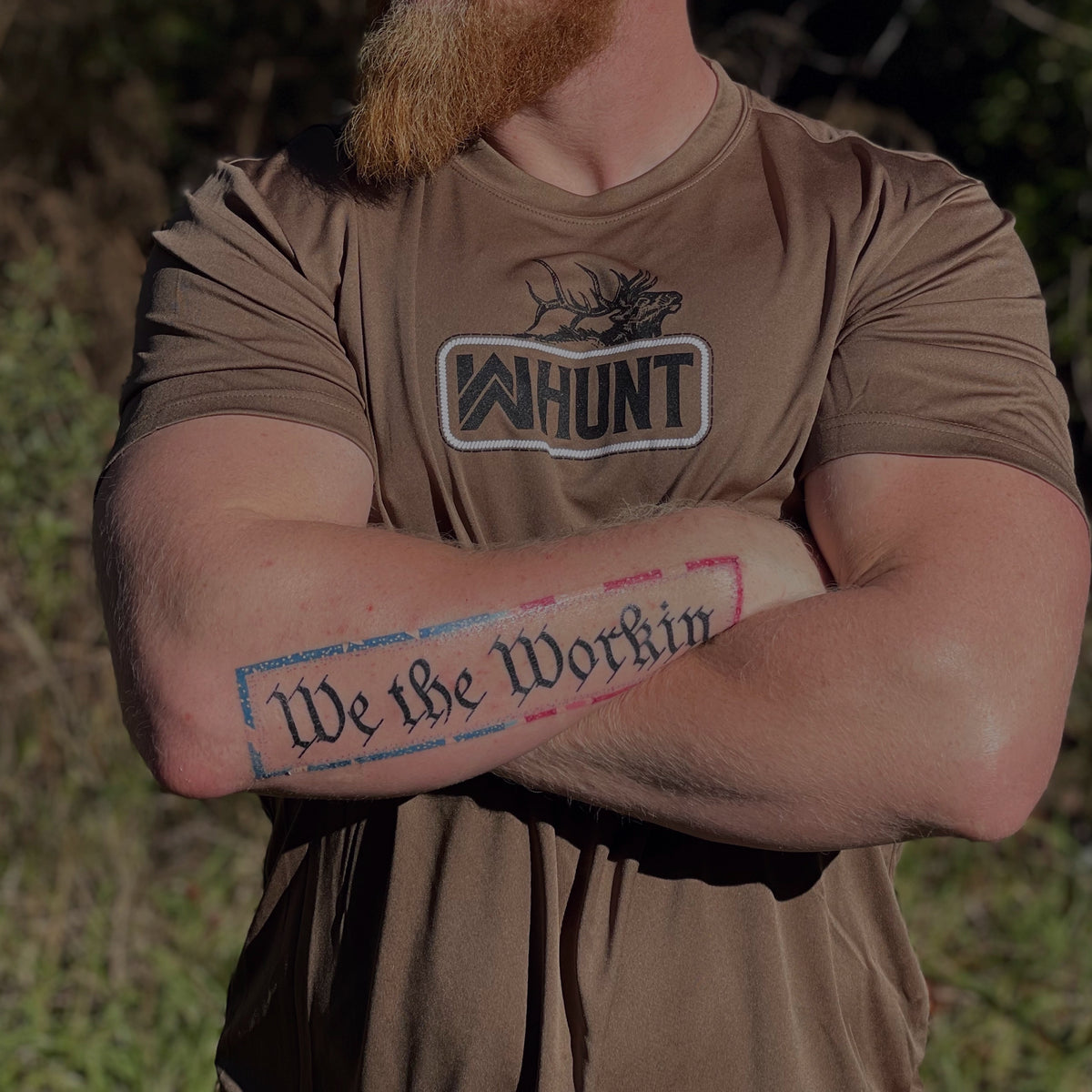 HUNT Collection. Man pictured from front outdoors in woods, wearing a WW HUNT Short Sleeve ultra lightweight tee in woodland brown, screen printed with our newest design, the WW HUNT "patch" style, with Elk, front and center on chest.