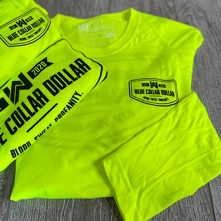 3 folded/stacked We Workin Hi-Viz long sleeve tees in Safety Yellow on wood tile background. Front of tee is printed with the We Workin BLUE COLLAR DOLLAR. BLOOD. SWEAT. PROFANITY. design in smaller left "pocket" size and back is same design but large, both printed in Black ink.