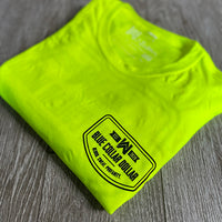 A single folded We Workin Hi-Viz long sleeve tee in Safety Yellow on wood tile background. Front of tee is printed with the We Workin BLUE COLLAR DOLLAR. BLOOD. SWEAT. PROFANITY. design in smaller left "pocket" size, printed in Black ink.