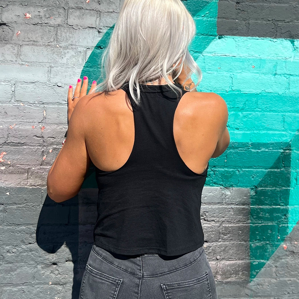 Woman wearing a WW black cropped racerback tank, shown from back. Blank/no print on back.