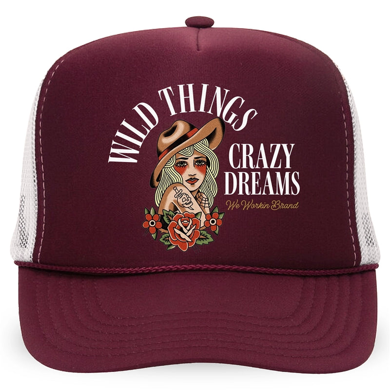 A WeWorkin Foam Trucker Snapback Hat in the Maroon/White colorway, on a white background, pictured from the front. The design shows “WILD THINGS—CRAZY DREAMS” text surrounding a full-color stylized tatted-woman image on the full front foam panel. We Workin Brand text in cursive in the bottom right of design.