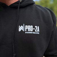 Man pictured from front wearing a WW PRO-2A black hoodie. WW "PRO-2A" design is printed in white and grey ink, smaller on chest left "pocket" area. 