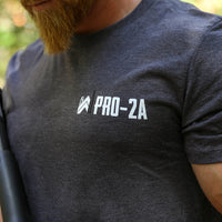 Man pictured from the front wearing a Steel Grey WeWorkin short sleeve tee. Graphic printed on left chest pocket area, includes our WW icon with 2 bullets replacing the left and right side of the Ws (mainly white icon with the right bullet in black) and PRO-2A text beside the icon on the right (same height) in White ink.