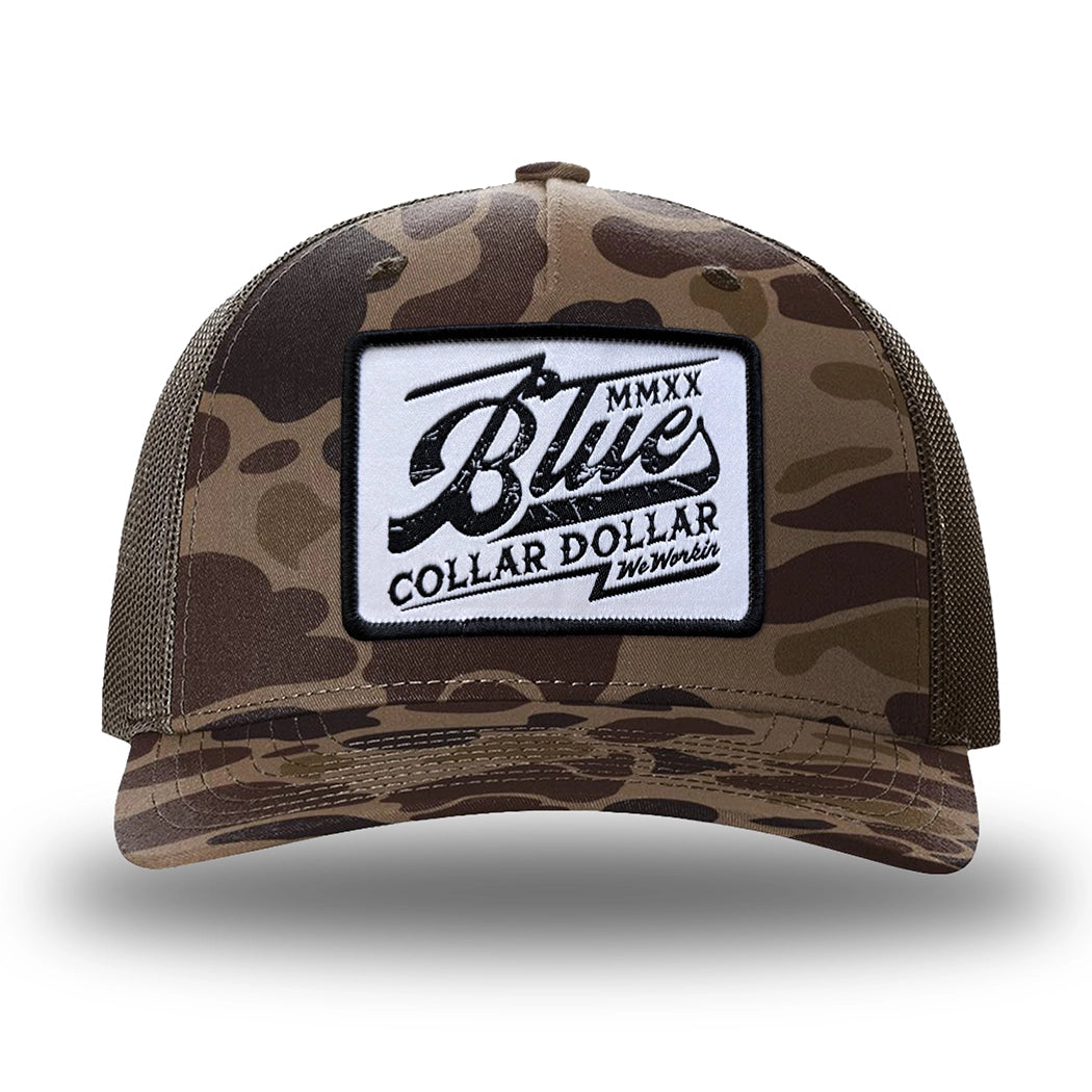 Bark Duck Camo/Brown two-tone WeWorkin hat—Richardson 112PFP snapback, 5-panel trucker, mesh-back style. We Workin "Blue Collar Dollar VINTAGE" (BCD-V) woven patch with black merrowed edge, on a white background with black distressed text/graphic, is centered on the front panel.