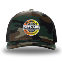 Green Camo/Black two-tone WeWorkin hat—Richardson 112PFP snapback, 5-panel trucker, mesh-back style. WE WORKIN custom GET HARD patch made of thermoplastic, lightweight, durable material is centered on the front panels in orange to yellow fade and black colors.