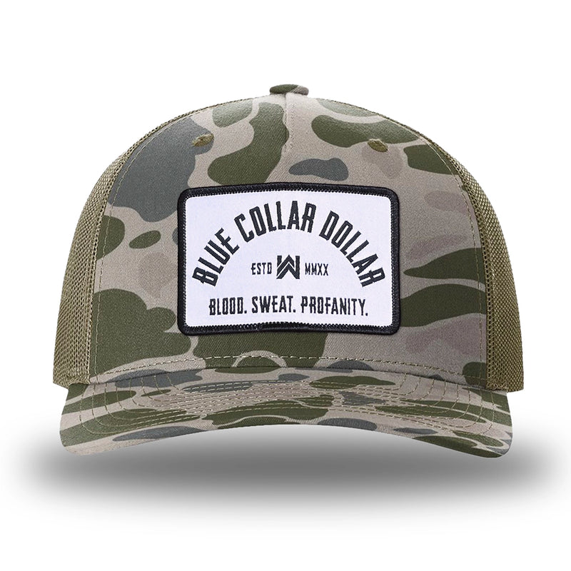 Marsh Duck Camo/Loden two-tone WeWorkin hat—Richardson 112PFP snapback, 5-panel trucker, mesh-back style. BLUE COLLAR DOLLAR ARCH (BCD-ARCH) woven patch with black merrowed edge, on a white background with black text, is centered on the front panel.