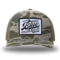 Marsh Duck Camo/Loden two-tone WeWorkin hat—Richardson 112PFP snapback, 5-panel trucker, mesh-back style. We Workin "Blue Collar Dollar VINTAGE" (BCD-V) woven patch with black merrowed edge, on a white background with black distressed text/graphic, is centered on the front panel.