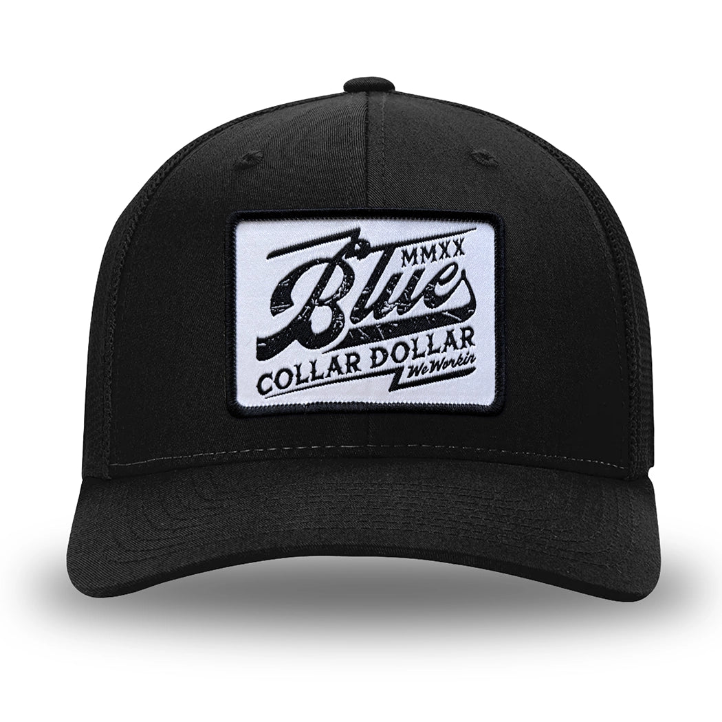 All Black Flex Fit style WeWorkin hat—Woven front with Poly mesh sides and back, Richardson 110 brand (R-Flex trucker). We Workin "Blue Collar Dollar VINTAGE" (BCD-V) woven patch with black merrowed edge, on a white background with black distressed text/graphic, is centered on the front panel.