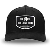 All Black Flex Fit style WeWorkin hat—Woven front with Poly mesh sides and back, Richardson 110 brand (R-Flex trucker). WeWorkin "Blue Collar Dollar" curved-bottom woven patch is centered on the front panels.