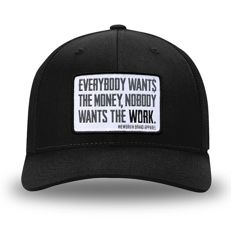 All Black Flex Fit style WeWorkin hat—Woven front with Poly mesh sides and back, Richardson 110 brand (R-Flex trucker). WeWorkin "Everybody Want$ the Money, Nobody Wants the WORK." [White Bkgd] rectangular woven patch is centered on the front panels.