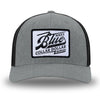 Heather Grey/Black Flex Fit style WeWorkin hat—Woven front with Poly mesh sides and back, Richardson 110 brand (R-Flex trucker). We Workin "Blue Collar Dollar VINTAGE" (BCD-V) woven patch with black merrowed edge, on a white background with black distressed text/graphic, is centered on the front panel.