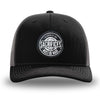 Black and Charcoal Grey two-tone WeWorkin hat—Richardson 112 brand snapback, retro trucker classic hat style. WeWorkin "SACRIFICES MUST BE MADE" circular woven patch is centered on the front panels.