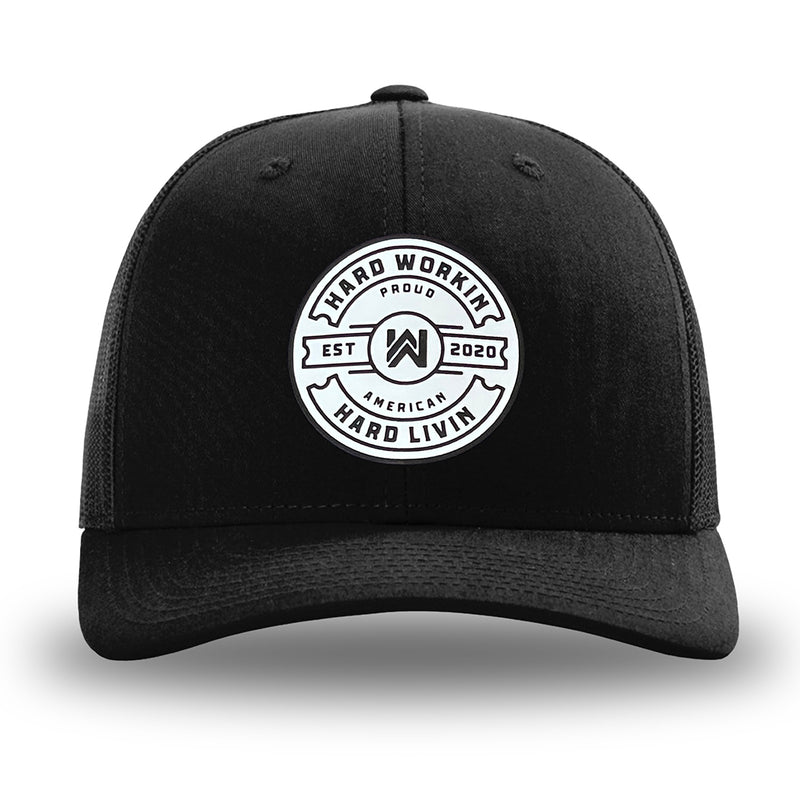 Solid Black WeWorkin hat—Richardson 112 brand snapback, retro trucker classic hat style. "HARD WORKIN. HARD LIVIN." Proud American silicone circle patch is centered on the front panels.
