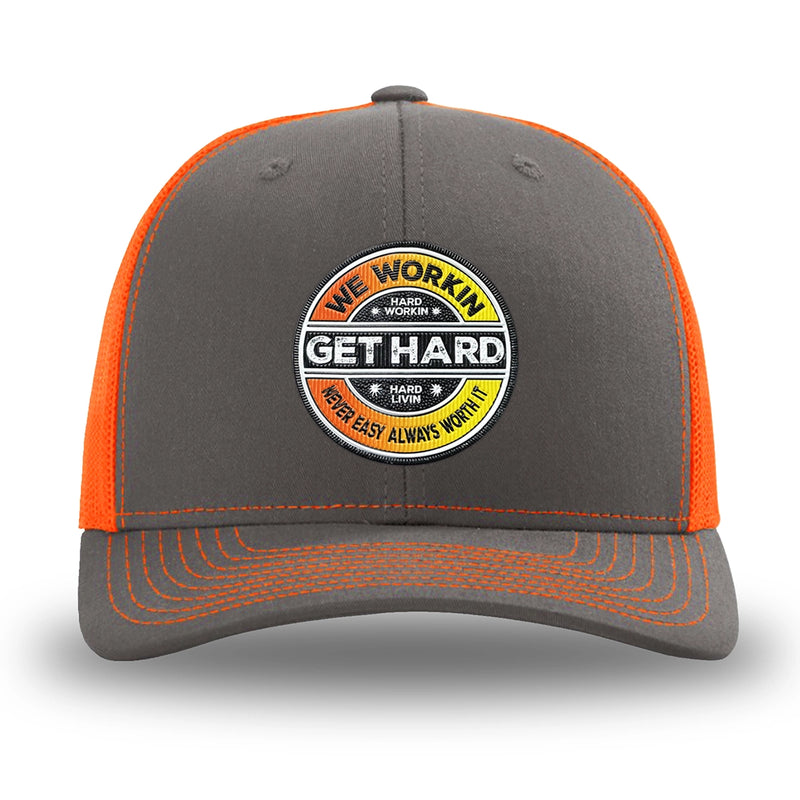 Neon/Safety Orange and Charcoal Grey two-tone WeWorkin hat—Richardson 112 brand snapback, retro trucker classic hat style. WE WORKIN custom GET HARD patch made of thermoplastic, lightweight, durable material is centered on the front panels in orange to yellow fade and black colors.
