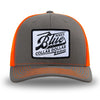 Neon/Safety Orange and Charcoal Grey two-tone WeWorkin hat—Richardson 112 brand snapback, retro trucker classic hat style. BLUE COLLAR DOLLAR VINTAGE (BCD-V) woven patch with black merrowed edge, on a white background with black, distressed text/design, centered on the front panels.