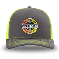 Neon/Safety Yellow and Charcoal Grey two-tone WeWorkin hat—Richardson 112 brand snapback, retro trucker classic hat style. WE WORKIN custom GET HARD patch made of thermoplastic, lightweight, durable material is centered on the front panels in orange to yellow fade and black colors.