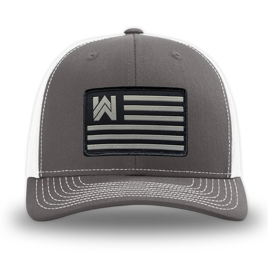 Charcoal/White WeWorkin hat—Richardson 112 brand snapback, retro trucker classic hat style. WE WORKIN FLAG woven patch with black merrowed edge is centered on the front panels.