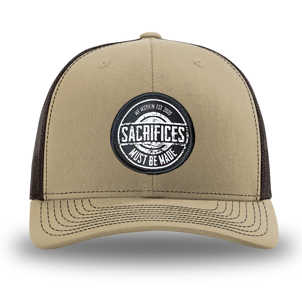 Khaki/Coffee WeWorkin hat—Richardson 112 brand snapback, retro trucker classic hat style. WeWorkin "SACRIFICES Must Be Made" circular woven patch, with black/white thread colors and black merrowed edge, is centered on the front panels.
