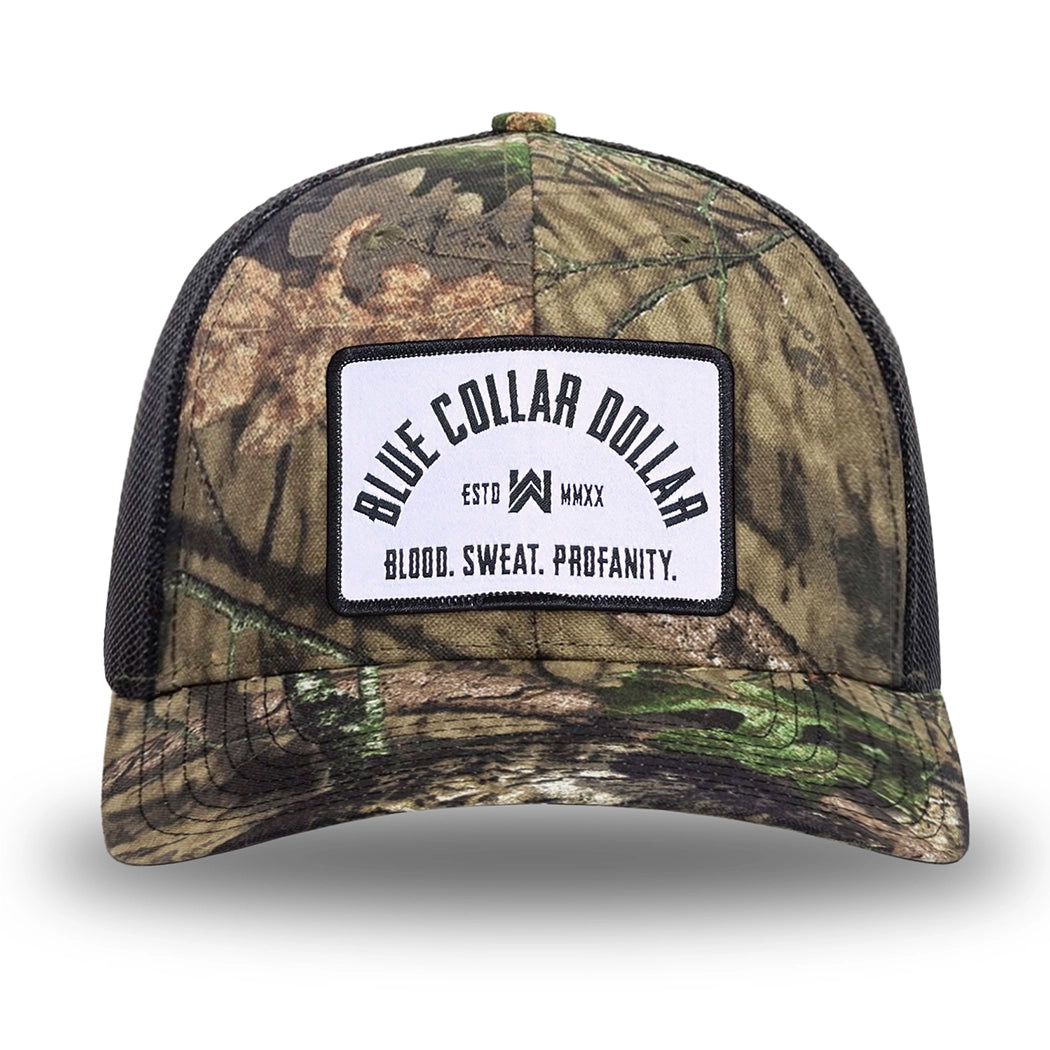 Mossy Oak/Country DNA/Black WeWorkin hat—Richardson 112 brand snapback, retro trucker classic hat style. BLUE COLLAR DOLLAR ARCH (BCD-ARCH) woven patch with black merrowed edge, on a white background with black text, is centered on the front panels.