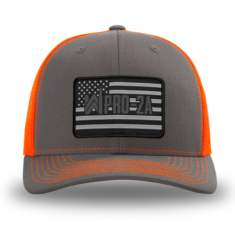 Neon/Safety Orange and Charcoal Grey two-tone WeWorkin hat—Richardson 112 brand snapback, retro trucker classic hat style. PRO-2A woven patch with black merrowed edge is centered on the front panels.