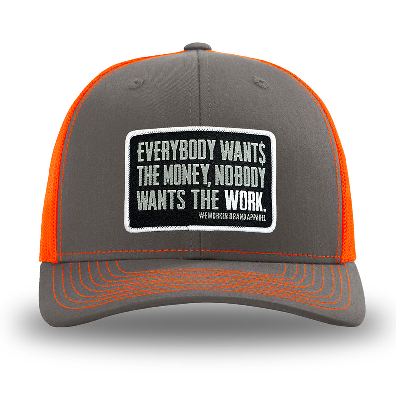 Neon/Safety Orange and Charcoal Grey two-tone WeWorkin hat—Richardson 112 brand snapback, retro trucker classic hat style. WeWorkin "Everybody Want$ the Money, Nobody Wants the WORK." rectangular woven patch is centered on the front panels.