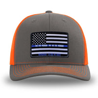 Neon/Safety Orange and Charcoal Grey two-tone WeWorkin hat—Richardson 112 brand snapback, retro trucker classic hat style. LEO FLAG woven patch with black merrowed edge is centered on the front panels.