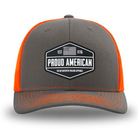 Neon/Safety Orange and Charcoal Grey two-tone WeWorkin hat—Richardson 112 brand snapback, retro trucker classic hat style. WeWorkin "PROUD AMERICAN" PVC patch is centered on the front panels.