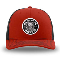 Red and Black WeWorkin hat—Richardson 112 brand snapback, retro trucker classic hat style. HARD WORK MATTERS woven patch with white merrowed edge, on a black background with HARD WORK MATTERS text encircling a Viking-style skull center graphic with MM XX on the left and right respectively—patch is centered on the front panels.