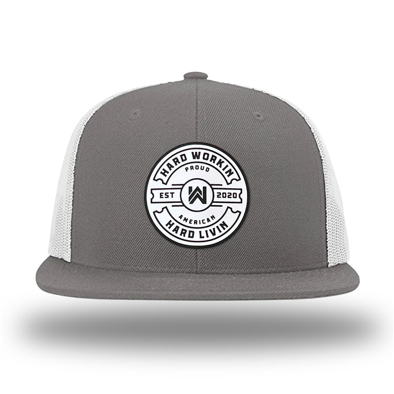Charcoal/White WeWorkin hat—Richardson 511 brand snapback, flatbill trucker hat style. "HARD WORKIN. HARD LIVIN." Proud American silicone circle patch is centered on the front panels.