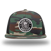 Green Camo/Black WeWorkin hat—Richardson 511 brand snapback, flatbill trucker hat style. HARD WORK MATTERS woven patch with white merrowed edge, on a black background with HARD WORK MATTERS text encircling a Viking-style skull center graphic with MM XX on the left and right respectively—patch is centered on the front panels.