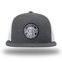 Heather Charcoal/White WeWorkin hat—Richardson 511 brand snapback, flatbill trucker hat style. WeWorkin "SACRIFICES Must Be Made" circular woven patch, with black/white thread colors and black merrowed edge, is centered on the front panels.