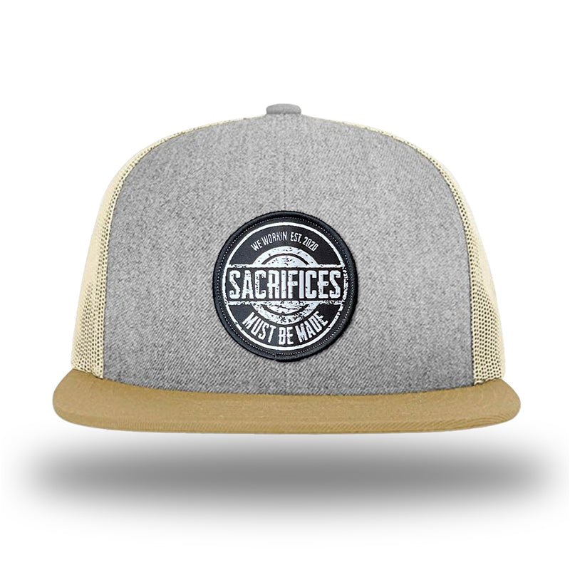 Heather Grey/Birch/Biscuit WeWorkin hat—Richardson 511 brand snapback, flatbill trucker hat style. WeWorkin "SACRIFICES Must Be Made" circular woven patch, with black/white thread colors and black merrowed edge, is centered on the front panels.