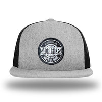 Heather Grey/Black WeWorkin hat—Richardson 511 brand snapback, flatbill trucker hat style. WeWorkin "SACRIFICES Must Be Made" circular woven patch, with black/white thread colors and black merrowed edge, is centered on the front panels.