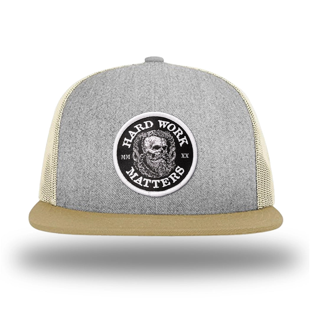 Heather Grey/Birch/Biscuit WeWorkin hat—Richardson 511 brand snapback, flatbill trucker hat style. HARD WORK MATTERS woven patch with white merrowed edge, on a black background with HARD WORK MATTERS text encircling a Viking-style skull center graphic with MM XX on the left and right respectively—patch is centered on the front panels.