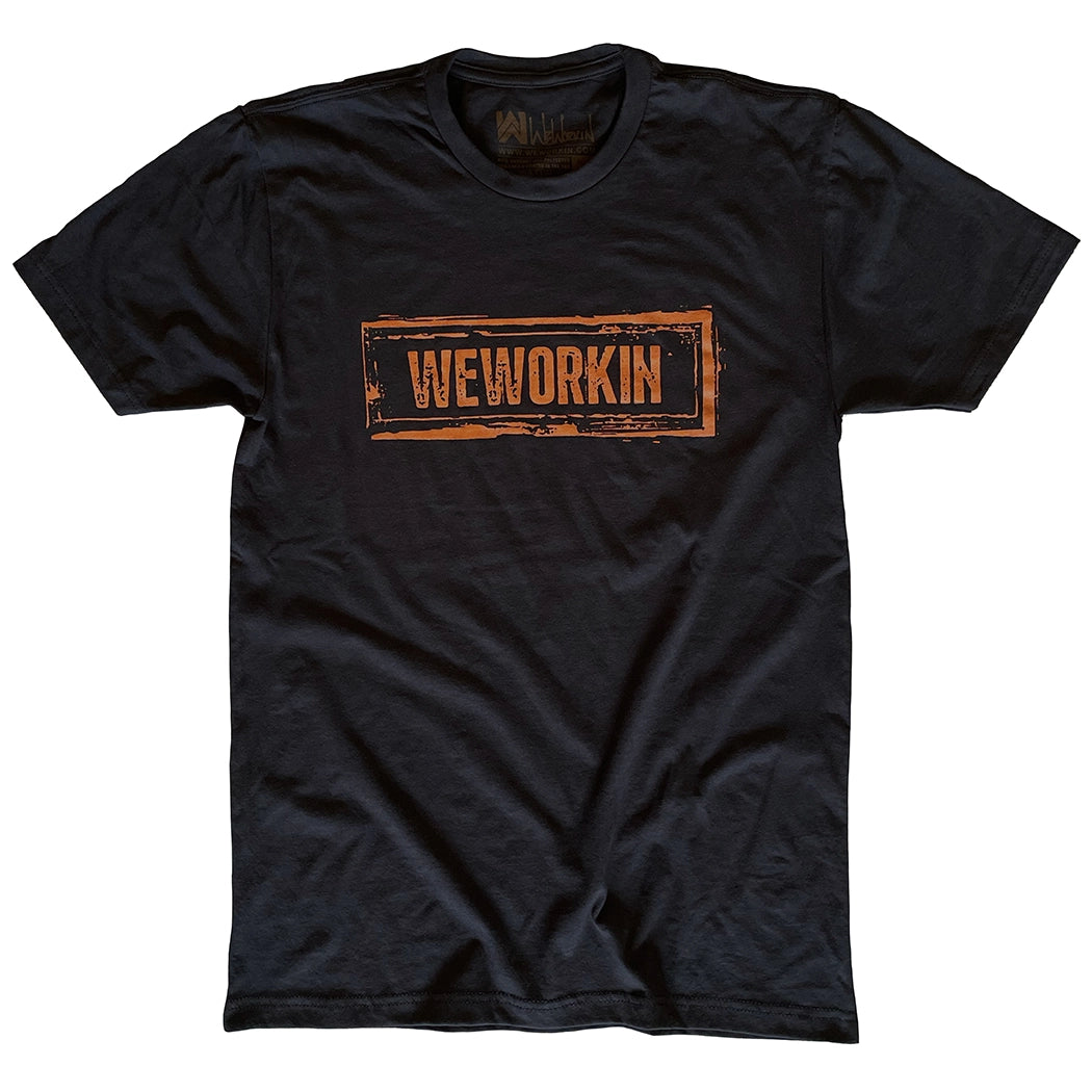 We Workin black graphic tee, boldly screenprinted with our original design "WEWORKIN Dirt Stamp" graphic, on the full front chest, in brown ink (on a white background).