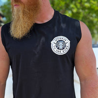 Man pictured from front, wearing a We Workin muscle tank in black. "WORKIN TO THE BONE" text circular graphic with a cow skull in the center is printed small in the left chest "pocket" area, in grey and white ink.