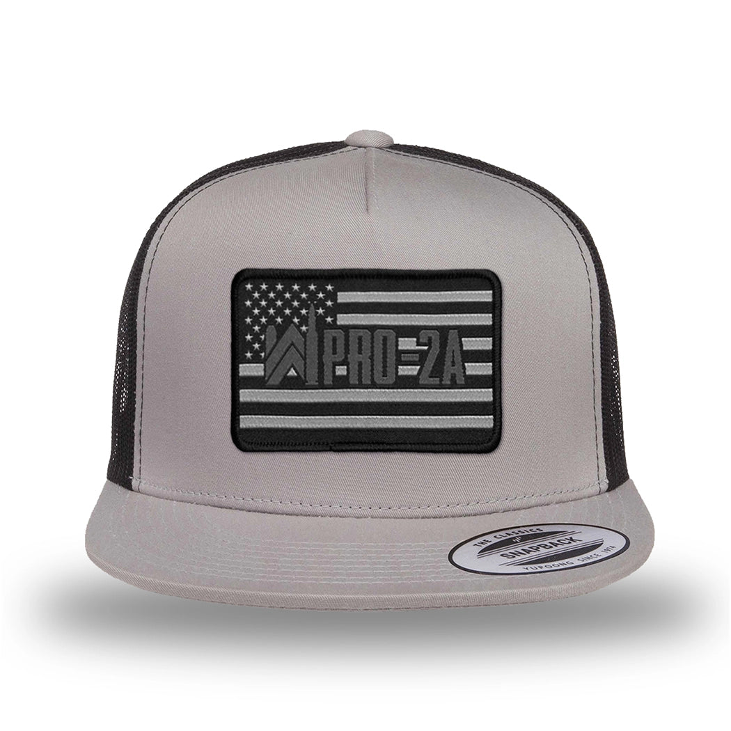 Silver/Black two-tone WeWorkin hat—snapback, 5-panel classic trucker, mesh sides/back style. PRO-2A woven patch with black merrowed edge is centered on the front panel.