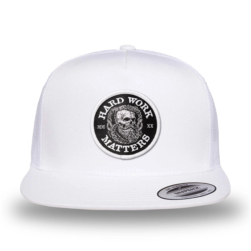 All white, high-profile, WeWorkin hat—snapback, 5-panel classic trucker, mesh sides/back style. HARD WORK MATTERS woven patch with white merrowed edge, on a black background with HARD WORK MATTERS text encircling a Viking-style skull center graphic with MM XX on the left and right respectively—patch is centered on the front panels.
