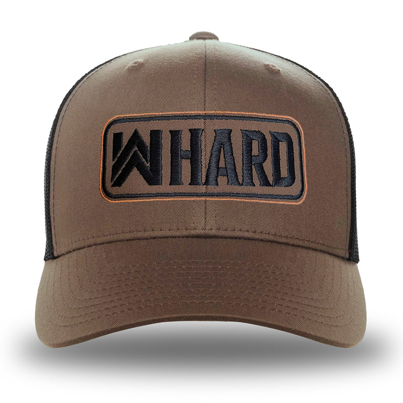 A Coyote Brown and Black Retro Trucker hat on white background. Embroidered with WW HARD "patch" style across the front (WW HARD icon/text in black thread, outer outline in orange thread, inner outline in black thread). Front 2 panels and bill are coyote brown, side/back mesh panels are black.
