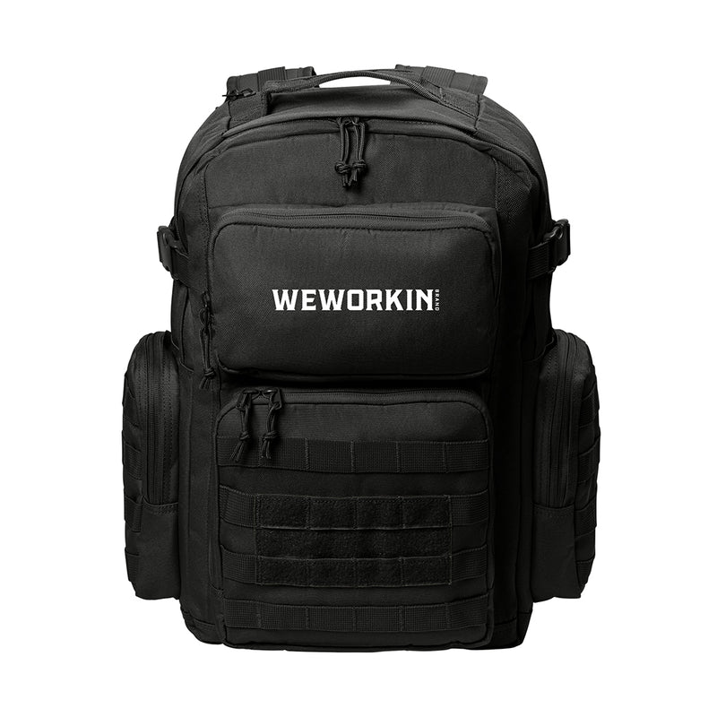 Stealth Black tactical backpack pictured from front on white background. WEWORKIN BRAND logo embroidered in white thread on the top front pocket center. Two side zippered accessory pockets with daisy chain, Top front zippered pocket embroidered, Web carry handle, Lower front zippered pocket with daisy chain and loop panel for badges and patches.