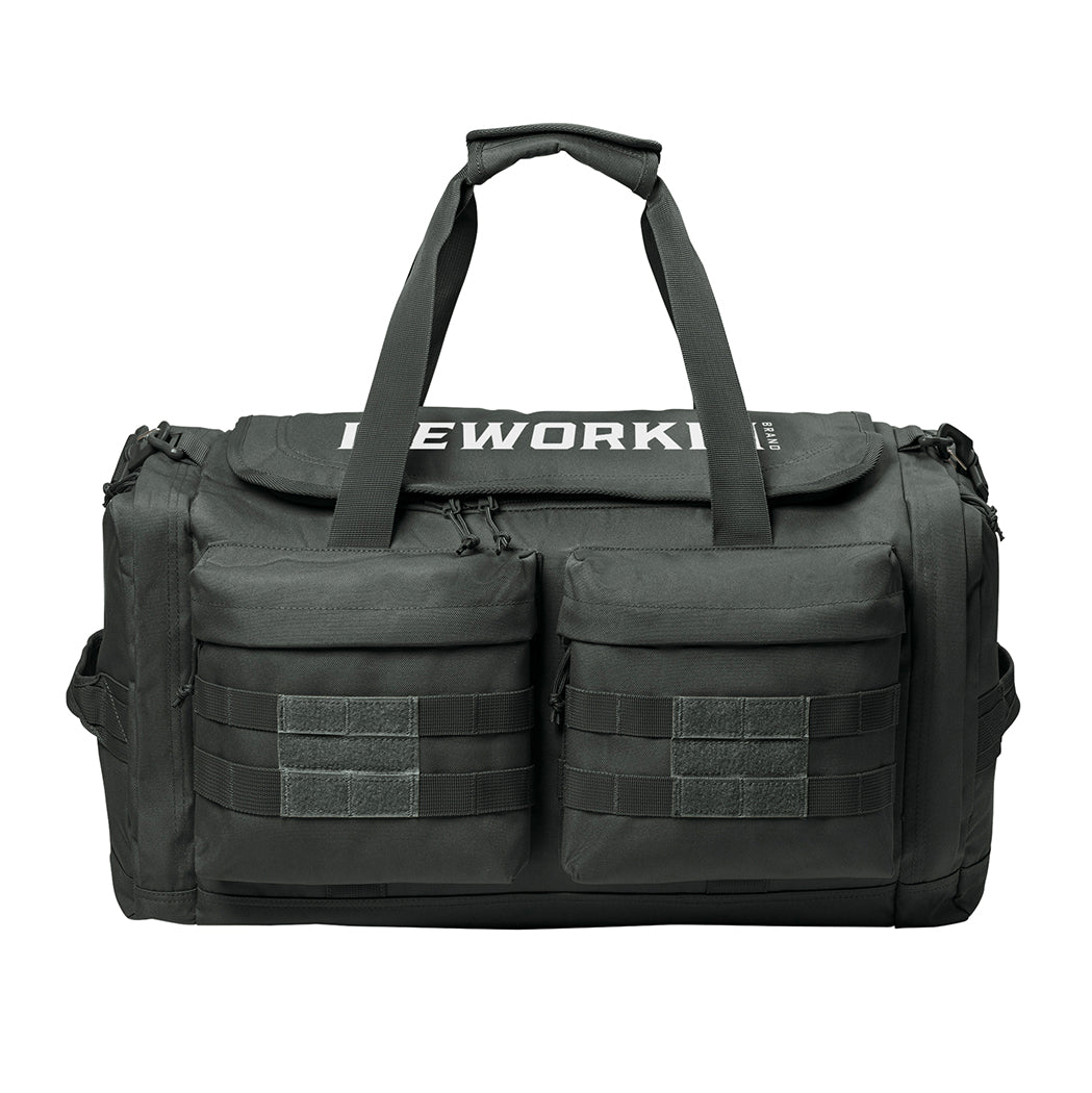 Charcoal Grey tactical duffle bag pictured from front on a white background. WEWORKIN BRAND logo embroidered in white thread on the top panel. 600D polyester canvas, Covered zipper D-shaped main compartment, [2] zippered end pockets, [2] Front zippered pockets with daisy chain/loop panels for patches (WW patches sold separately), Web carry handles with padded handle wrap, Web grab handles on both ends, Removable/adjustable padded shoulder strap.
