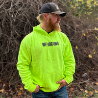 Man pictured from front wearing a We Workin premium Safety Yellow hoodie. WEWORKIN BRAND printed on the front chest in black ink.