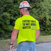Man outdoors, hard hat on, pictured from back, wearing the We Workin Hi-Viz Safety Yellow short sleeve tee. Back is printed with the tagline "Everybody Wants the Money, Nobody Wants the WORK." in black ink, except the word WORK is in grey ink.