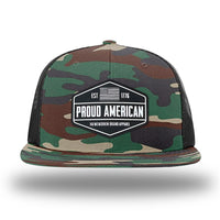 Green Camo/Black WeWorkin hat—Richardson 511 brand snapback, flatbill trucker hat style. WeWorkin black and white "PROUD AMERICAN" silicone patch is centered on the front panels.